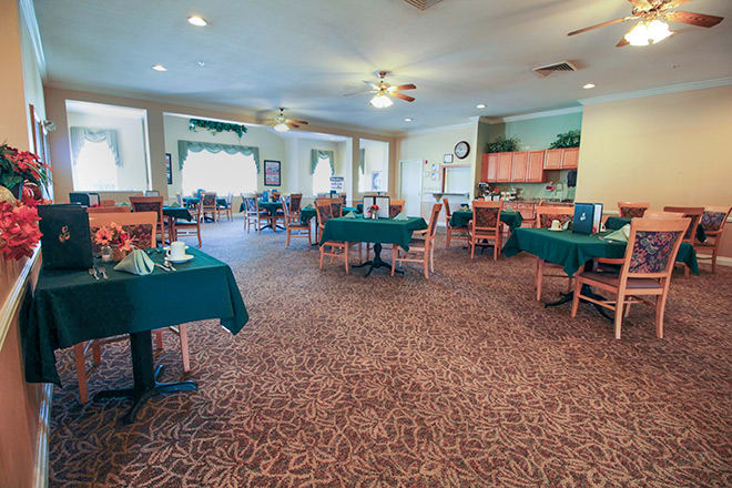 A spacious dining area with neatly arranged tables and chairs, featuring a warm and inviting decor.