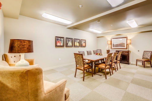 A well-lit meeting room featuring a large table surrounded by chairs and artwork on the walls.