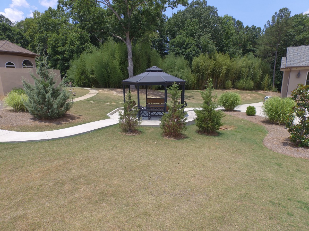 A serene park scene featuring a gazebo and winding pathways surrounded by greenery.