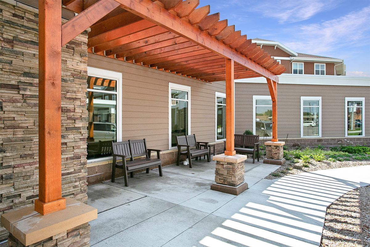 A modern patio area featuring a wooden pergola and comfortable outdoor seating.
