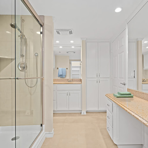 A sleek and modern bathroom featuring clean lines, a glass shower, and ample storage.