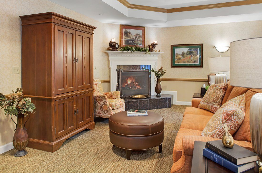 A cozy living room with a wooden cabinet, fireplace, and comfortable seating.