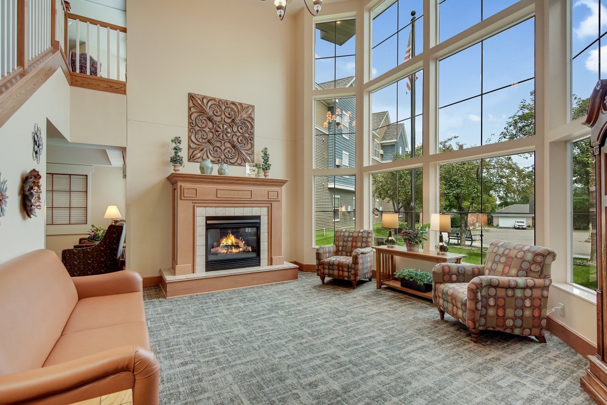 A spacious and modern living room with a fireplace and large windows, featuring comfortable seating and elegant decor.