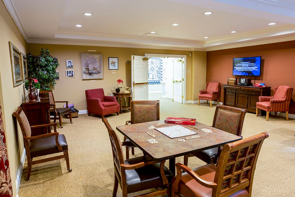 A cozy community room with comfortable seating and a game table, designed for relaxation and social activities.