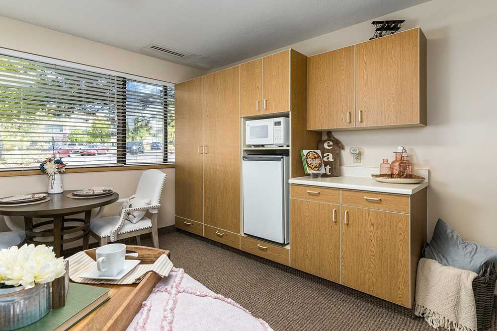 A compact and cozy kitchenette with wooden cabinets and modern appliances.