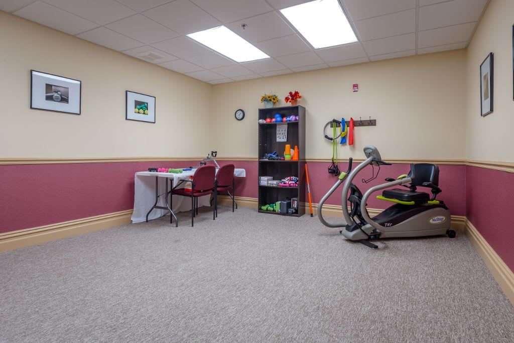 A small indoor exercise and therapy room equipped with various fitness tools and furniture.