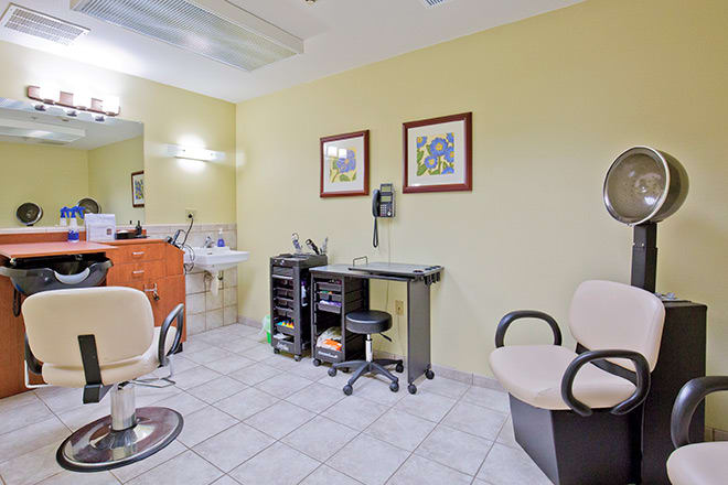 A tidy and well-equipped hair salon with chairs, a sink, and mirrors.