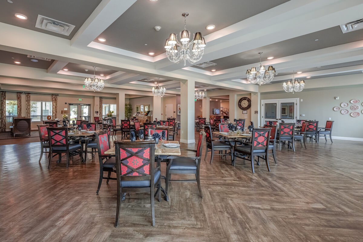 Elegant dining room with chandeliers and neatly arranged tables and chairs.