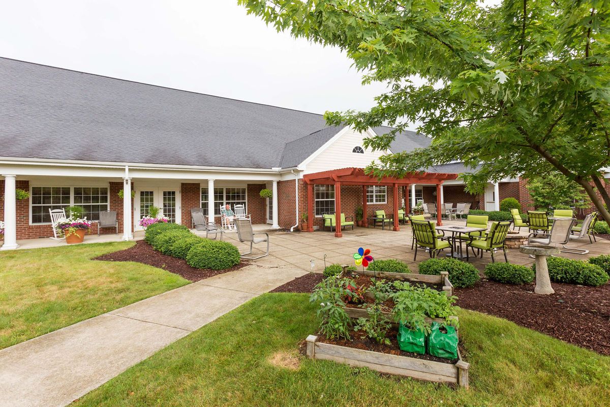 A well-maintained garden with outdoor seating next to a brick building.