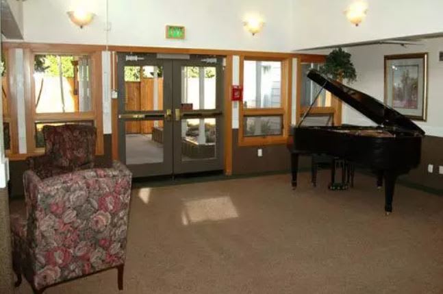 A cozy lobby area with a grand piano and seating.