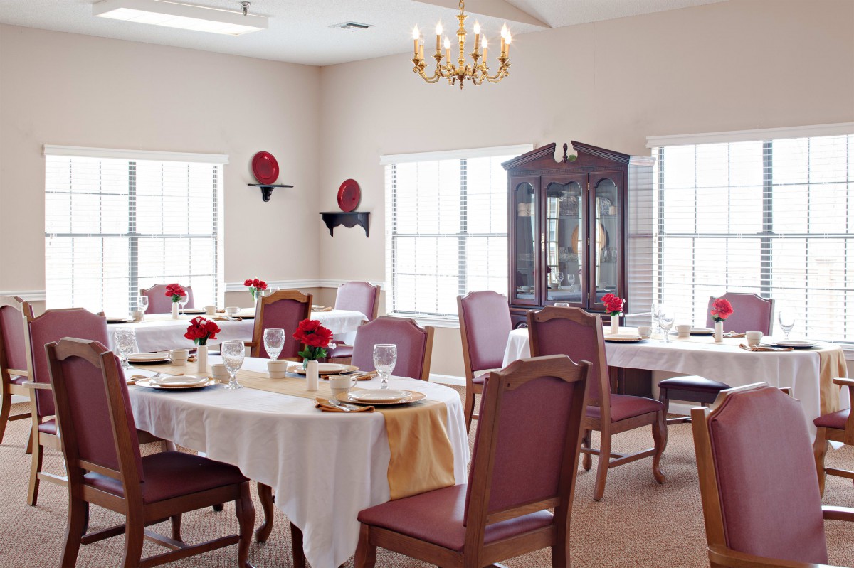 An elegant dining room with well-set tables and red chairs.