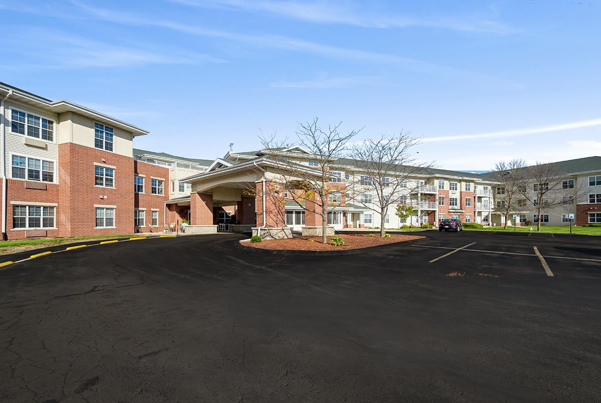 A view of a residential building with a paved driveway in front.