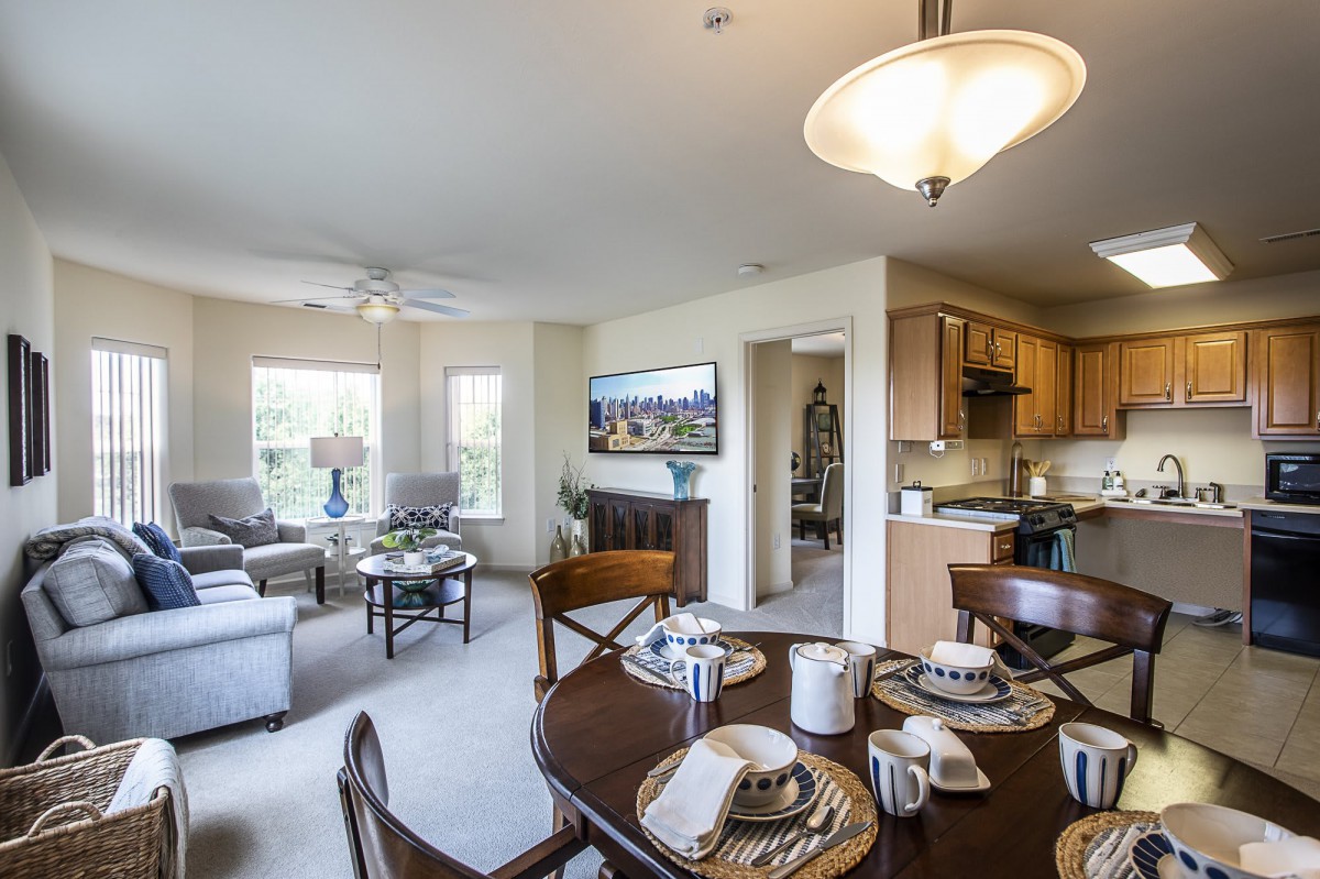 A modern open-concept living space featuring a comfortable living room, dining area, and kitchen.