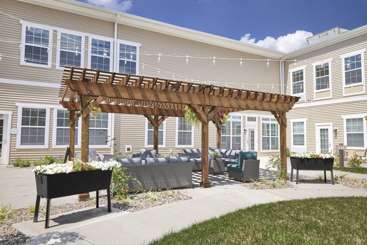 A tranquil outdoor patio with a wooden pergola and seating area.