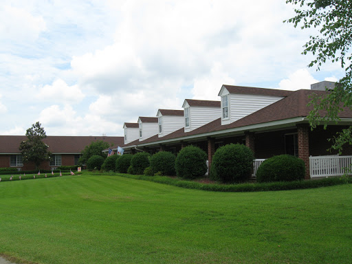 A row of residential buildings with manicured lawns under a cloudy sky.