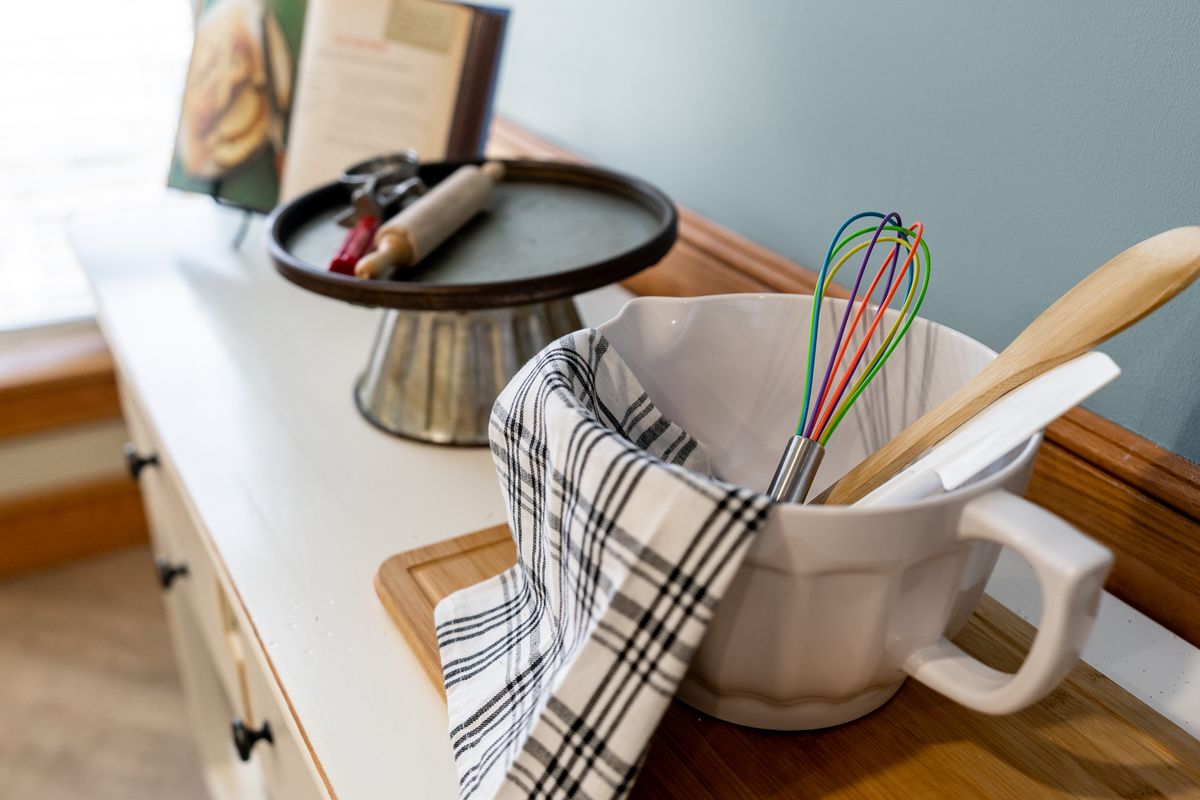A kitchen setup with a mixing bowl, colorful whisk, and baking tools on display.