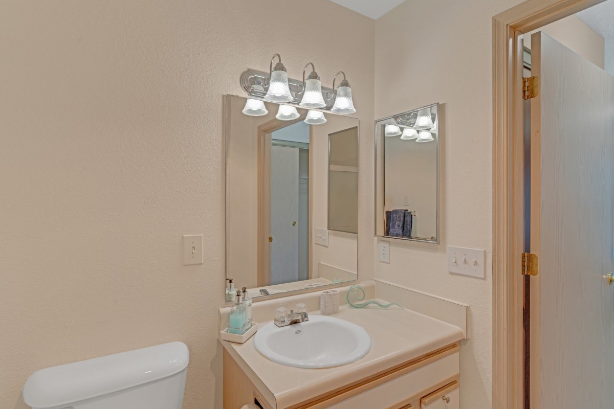 A well-lit bathroom with a sink and mirror.