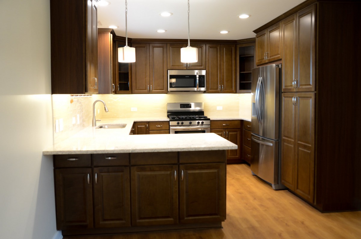 A modern kitchen with wooden cabinets and stainless steel appliances.