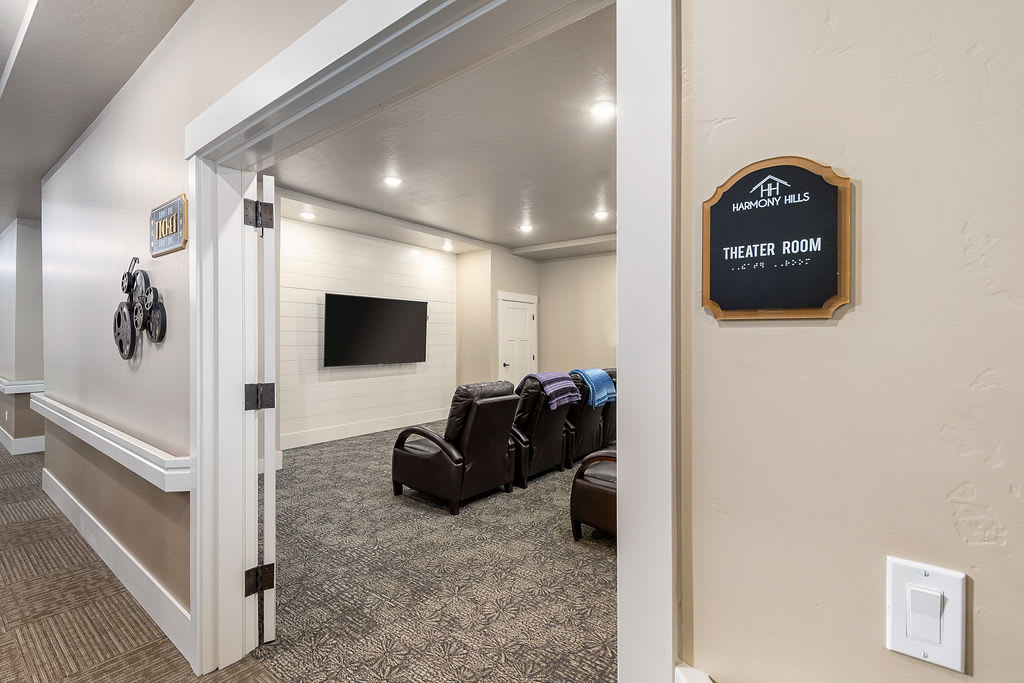 A cozy home theater room with reclining chairs and a large TV screen.