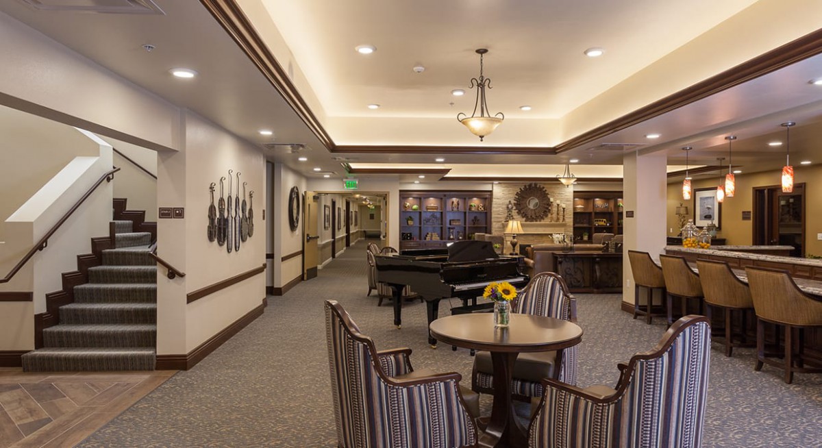 A cozy lounge area featuring a piano, comfortable seating, and elegant decor.