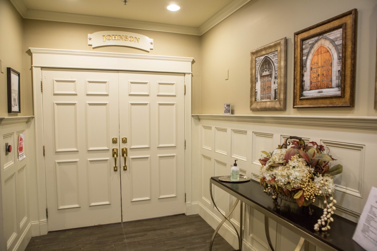 A well-decorated hallway with double doors and elegant furnishings.