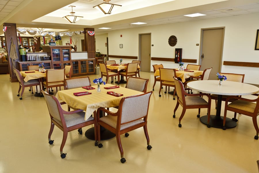 An empty dining area with neatly arranged tables and chairs in a well-lit indoor setting.