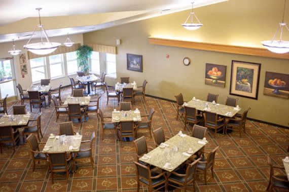 An empty dining room with neatly arranged tables and chairs.