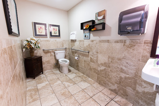 A clean and well-designed bathroom with tiled floors and decorative elements.