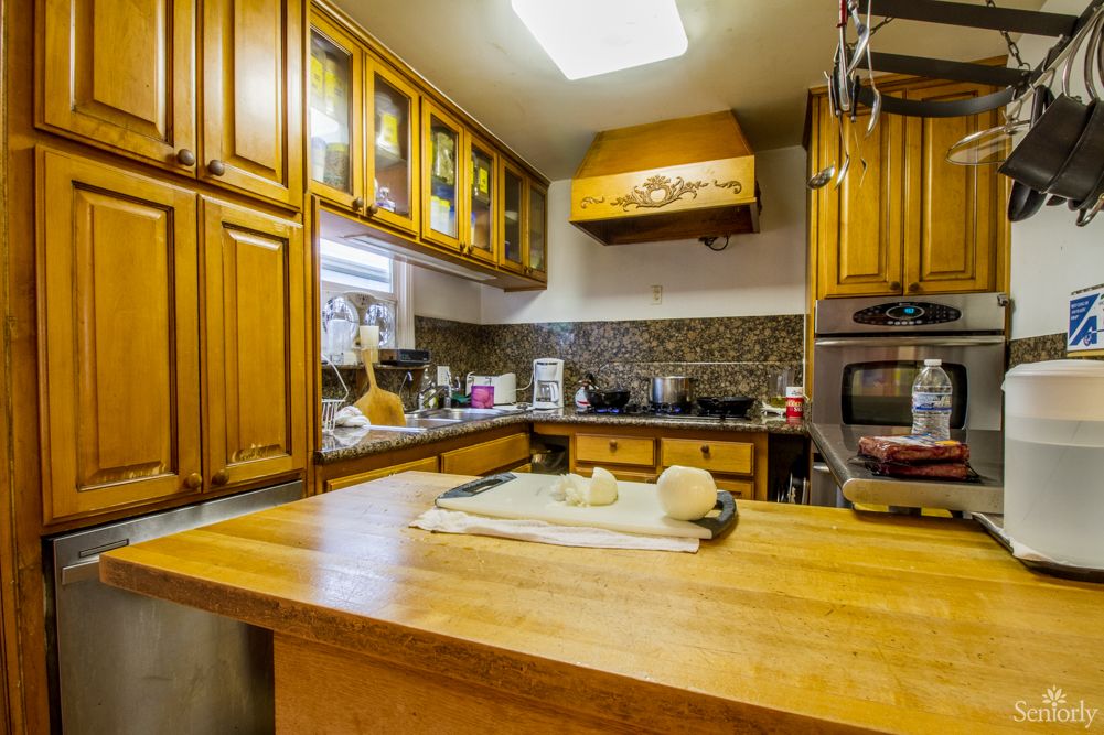 A cozy kitchen with wooden cabinets and a countertop featuring dough ready for baking.