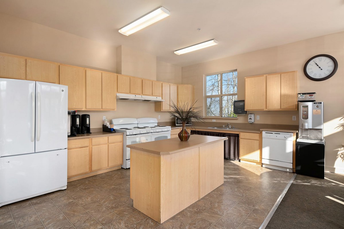 A modern and spacious kitchen featuring wood cabinets and a central island.