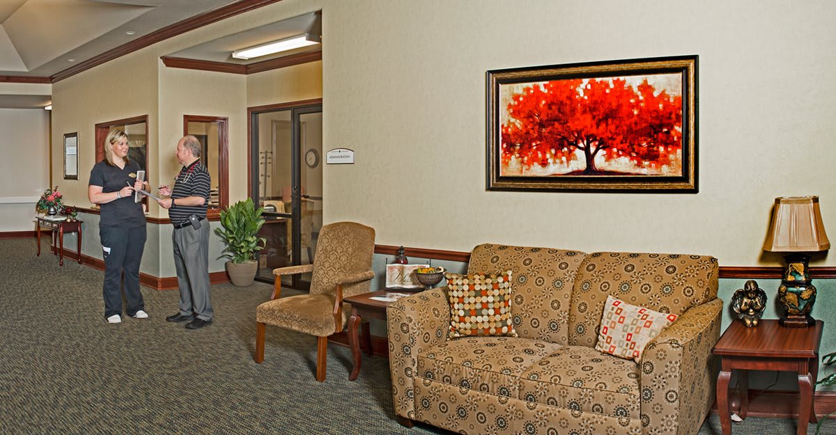 A cozy waiting room with a sofa, chairs, and a vibrant painting on the wall.