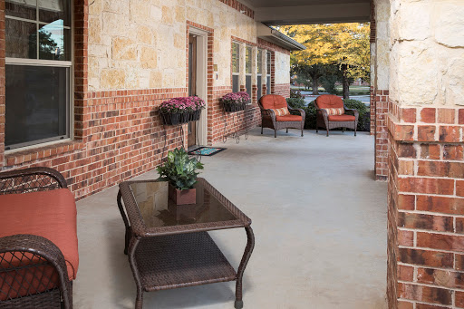 A cozy outdoor patio space featuring comfortable seating and decorative plants, perfect for relaxation.
