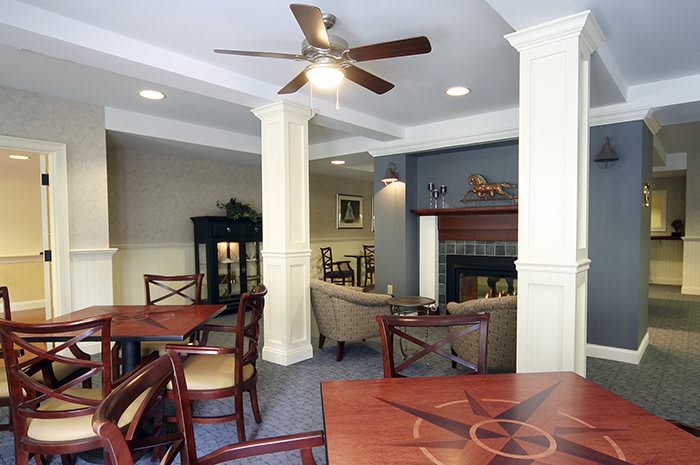 A cozy living room with wooden furniture, a ceiling fan, and a fireplace.