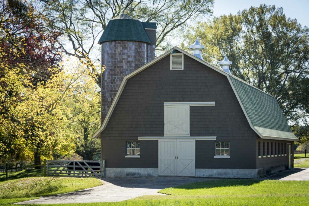 A classic barn and silo set in a picturesque rural landscape.