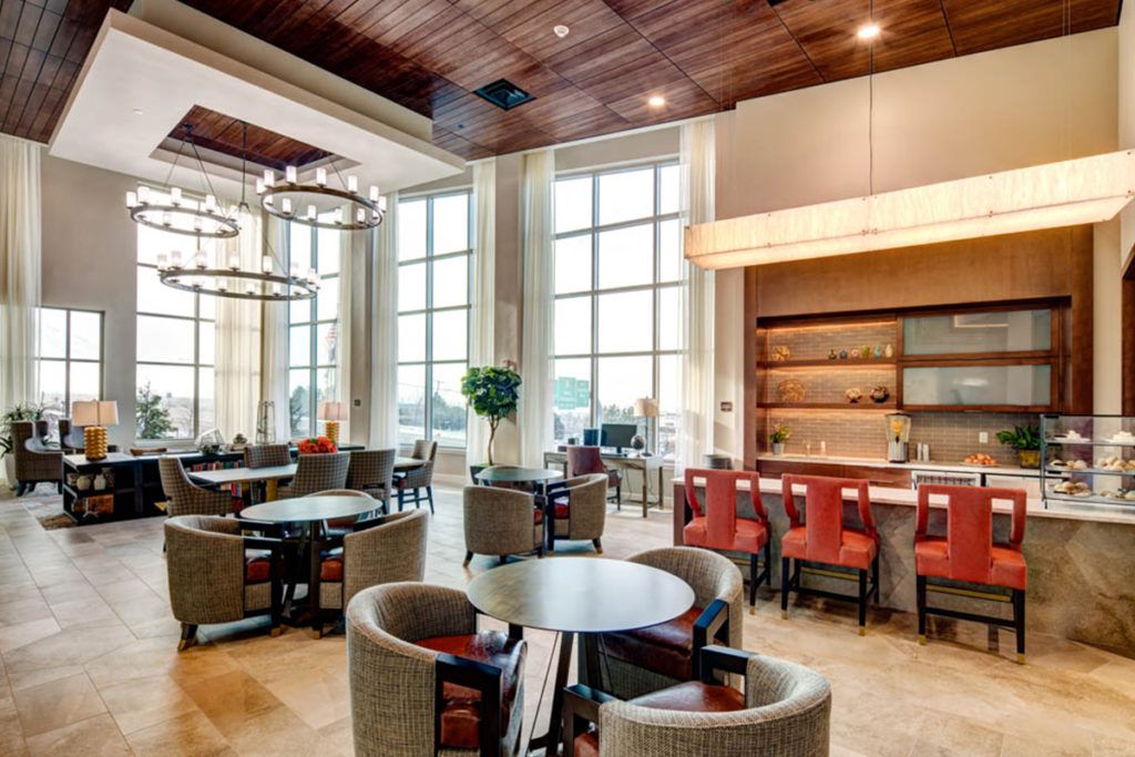 A stylish and modern dining area with ample seating and natural light streaming in through large windows.