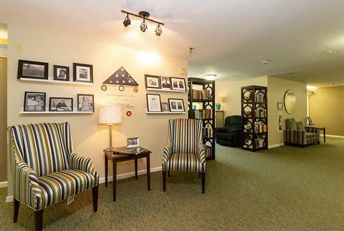 A cozy living room with striped chairs, wall decorations, and ambient lighting.