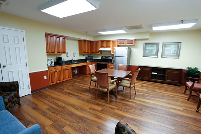 A modern kitchen and dining area with wooden floors and cabinets.