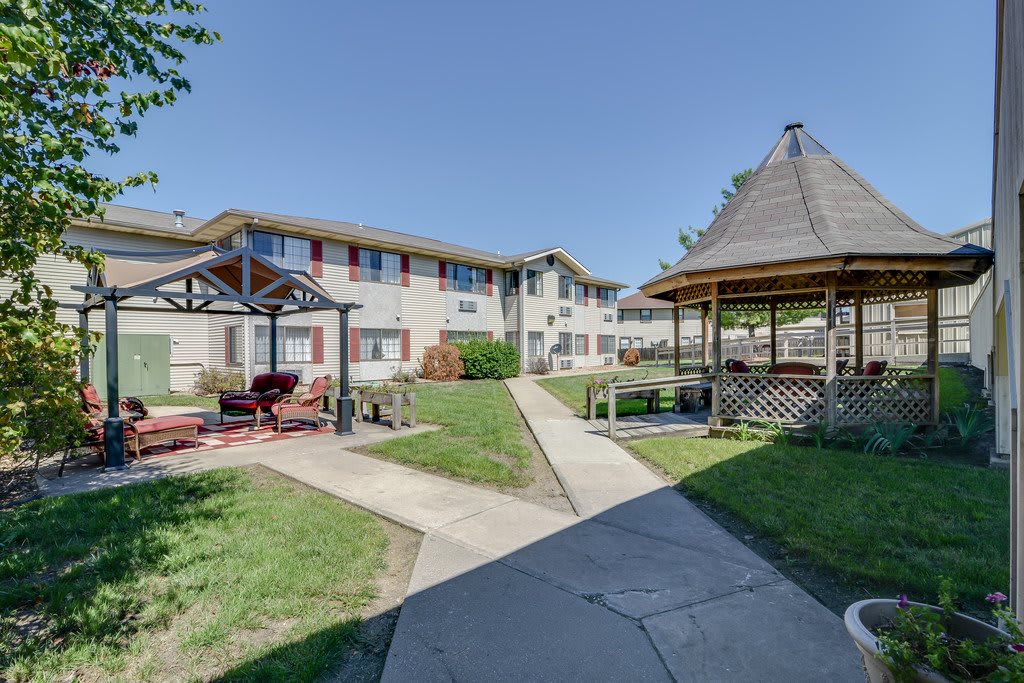 A pleasant courtyard with a gazebo and a residential building in the background.