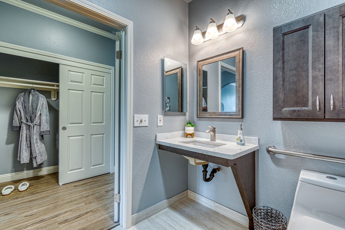 A modern bathroom with a sleek sink, framed mirror, and bright lighting.