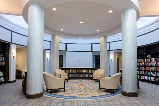 A modern lobby featuring comfortable seating, decorative columns, and a bookshelf.