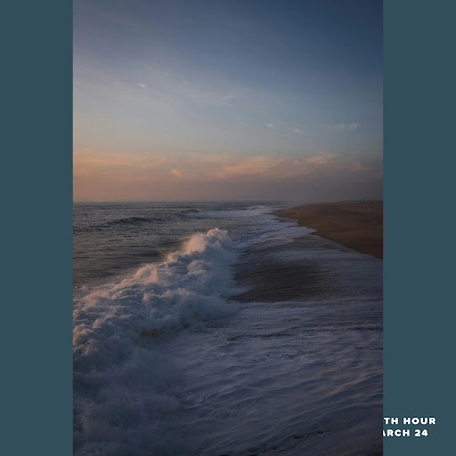 A tranquil sunset over the ocean, highlighting the gentle waves lapping at the shore.