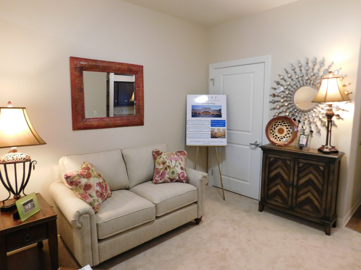 A cozy living room with a sofa, decorative mirror, and stylish accents.