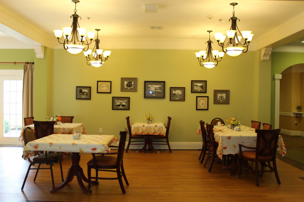 A cozy restaurant dining area with tables, chairs, and elegant chandeliers.