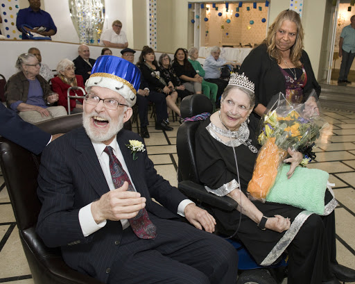 A joyous celebration featuring a couple in festive attire, surrounded by friends and family.