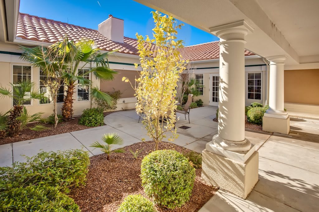 A beautifully landscaped courtyard featuring a mix of greenery and architectural details.