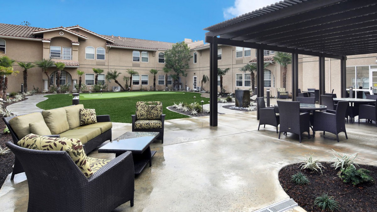 A beautifully landscaped patio area with comfortable seating and a view of the garden.