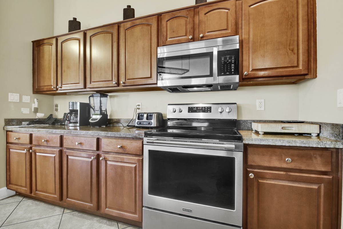 A modern kitchen with wooden cabinets and stainless steel appliances.