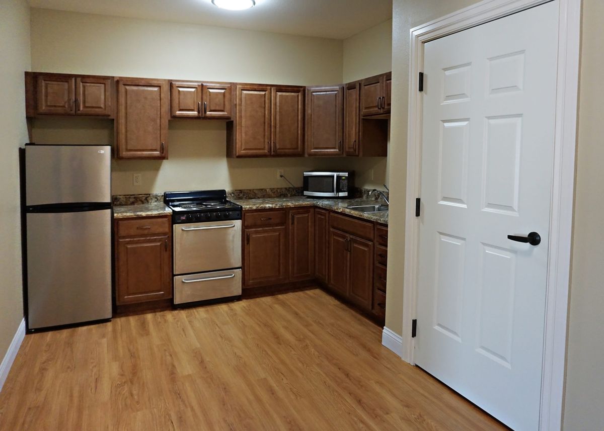 A modern kitchen with wooden cabinets and stainless steel appliances.