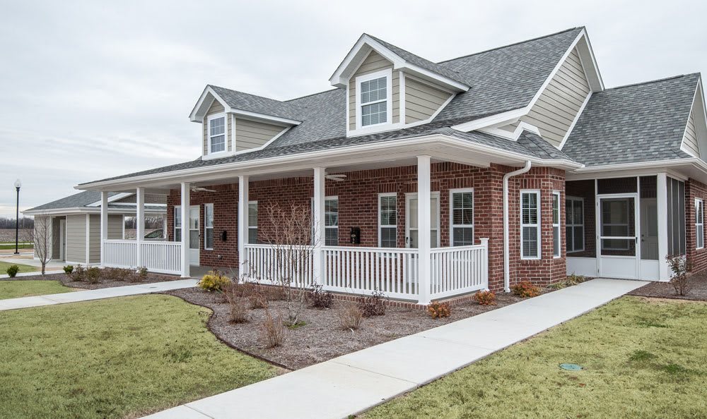 A modern duplex house with a brick exterior and spacious front porch.