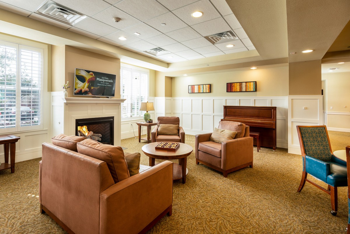 A cozy living room with comfortable seating, a fireplace, and a piano.